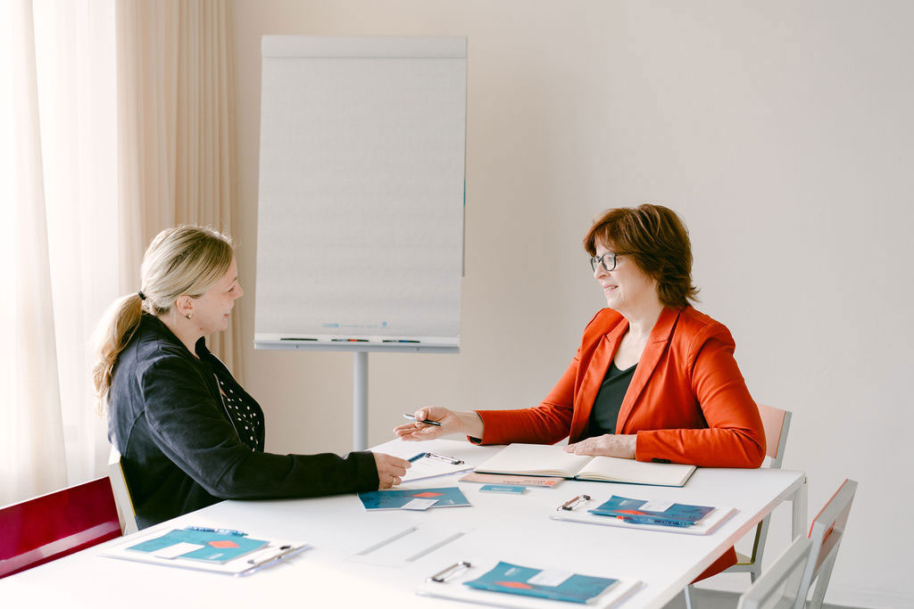 Veronika von Rüden, HR-Consulting und Unternehmensentwicklung, spricht mit einer Kundin, beide sitzen an einem Besprechungstisch